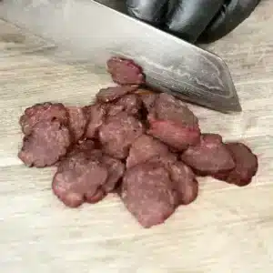 Kiełbasa drobiowa z piersi z kaczki krojona na desce